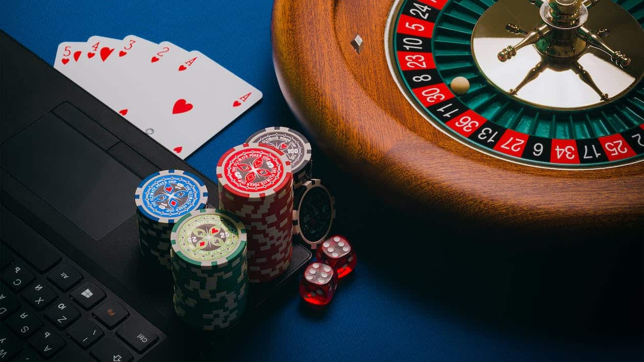 plan sur le clavier d'un ordinateur portable avec des jetons de casino, des cartes et une roulette