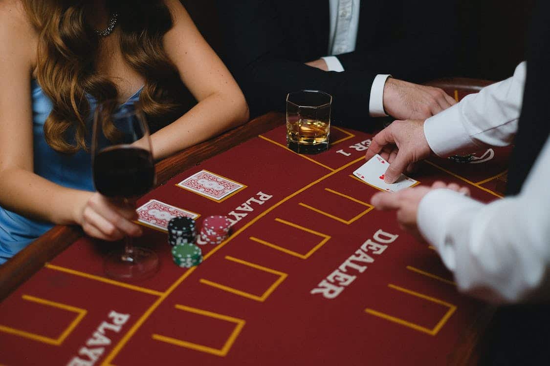 femme avec son verre de vin a une table de blackjack