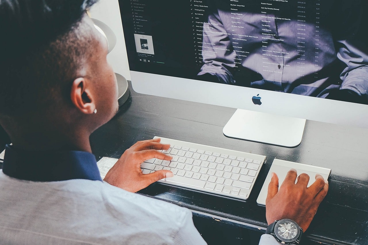 homme devant l'ecran d'un ordinateur imac